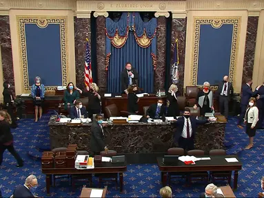 Anggota parlemen mengevakuasi diri saat pengunjuk rasa masuk ke Gedung Capitol Hill di Washington DC, Amerika Serikat, Rabu (6/1/2021). Massa pendukung Donald Trump menyerbu Gedung Capitol Hill untuk membatalkan pemilihan presiden Amerika Serikat. (Senate Television via AP)