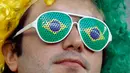 Suporter Brasil menggunakan kacamata unik menunggu dimulainya laga terakhir penyisihan grup E Piala Dunia 2018 melawan Serbia di Stadion Spartak, Rusia, Rabu (27/6). Brasil sukses melaju ke babak 16 besar usai menang 2-0. (AP Photo/Victor R. Caivano)