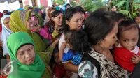 Sejumlah warga tertib mengantri membeli kebutuhan pokok dalam Pasar Murah Ramadan di Mesjid Jami Luar Batang, Jakarta, Kamis (9/7/2015). Pasar Murah Ramadan dimulai dari 29 Juni - 16 Juli 2015. (Liputan6.com/Faizal Fanani)