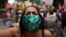 Seorang wanita menghadiri protes penanganan Presiden Brasil Jair Bolsonaro terhadap pandemi COVID-19 pada Hari Kemerdekaan di Rio de Janeiro, Selasa (7/9/2021). Ribuan orang yang turun ke jalan terbagi dalam dua kubu yaitu pendudukung serta penentang Bolsonaro. (AP Photo/Silvia Izquierdo)
