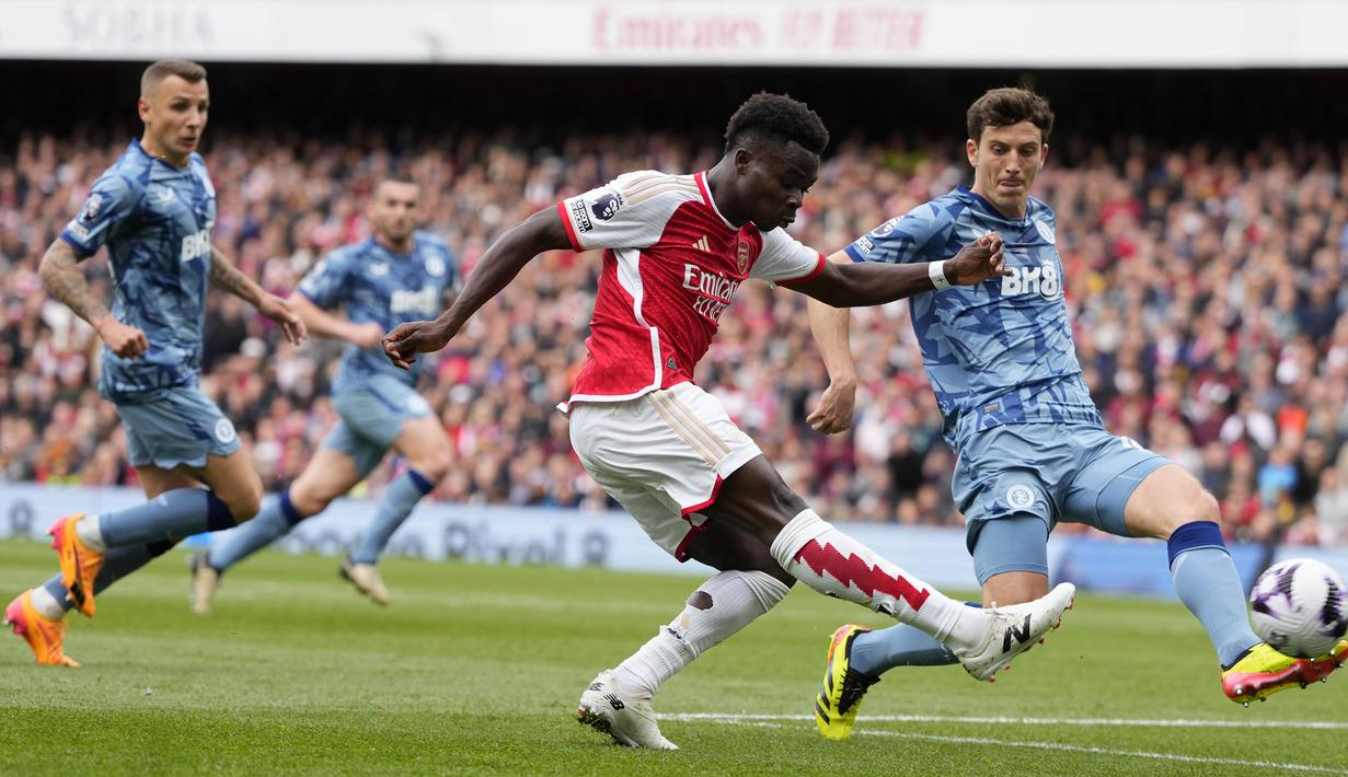 Gelandang Arsenal, Bukayo Saka melepaskan tendangan yang berusaha diblok bek Aston Villa, Pau Torres pada laga pekan ke-33 Premier League 2023/2024 di Emirates Stadium, London, Minggu (14/4/2024). (AP Photo/Kirsty Wigglesworth)