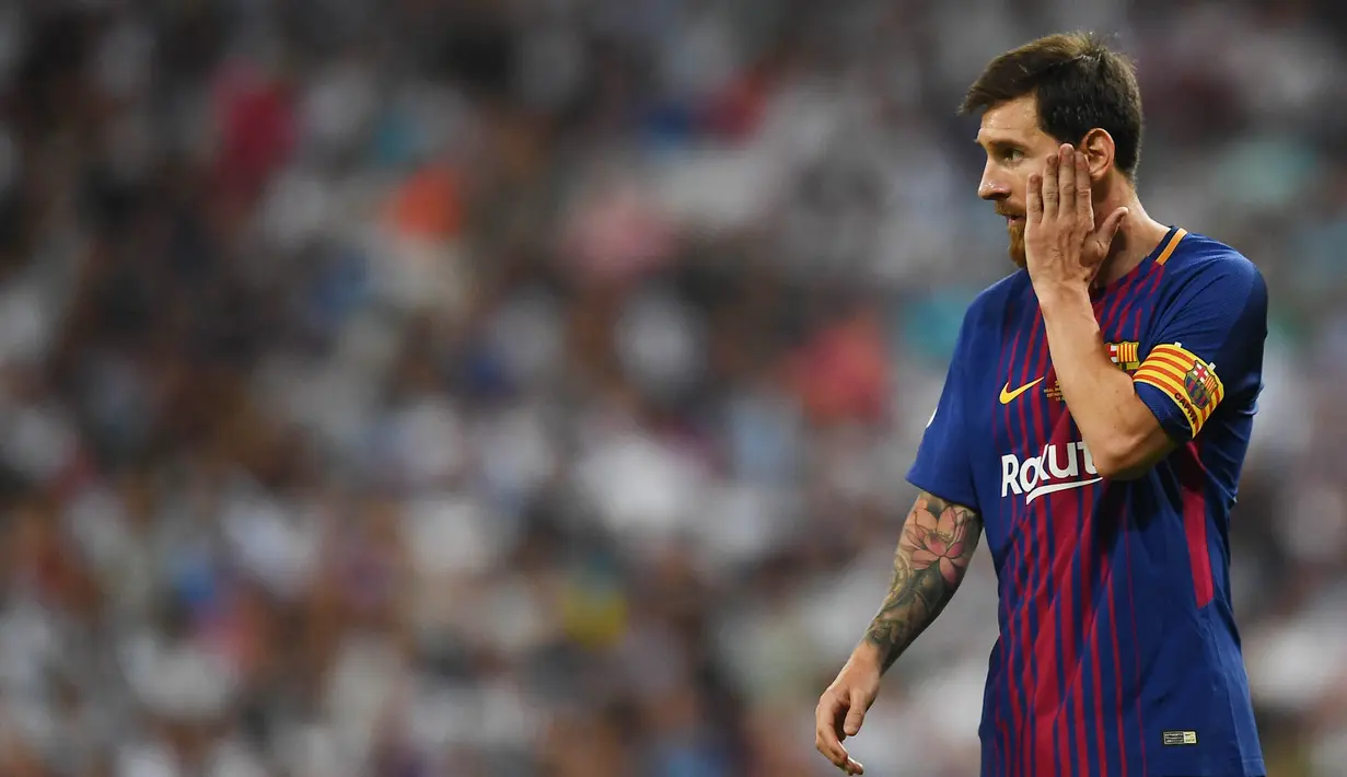 Striker Barcelona, Lionel Messi, mengusap pipinya usai takluk dari Real Madrid pada laga Piala Super Spanyol 2017 di Stadion Santiago Bernabeu, Rabu (16/8/2017). Real Madrid menang 2-0 atas Barcelona. (AFP/Gabriel Bouys)