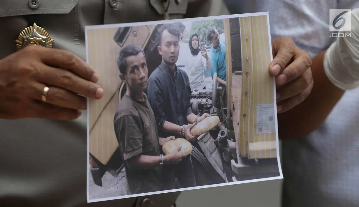 Petugas menunjukkan foto tersangka saat menggelar rilis barang bukti ganja di Polda Metro Jaya, Jakarta, Selasa (24/4). 142,8 kilogram ganja dan 5 orang tersangka berhasil diamankan petugas kepolisian. (Liputan6.com/Arya Manggala)