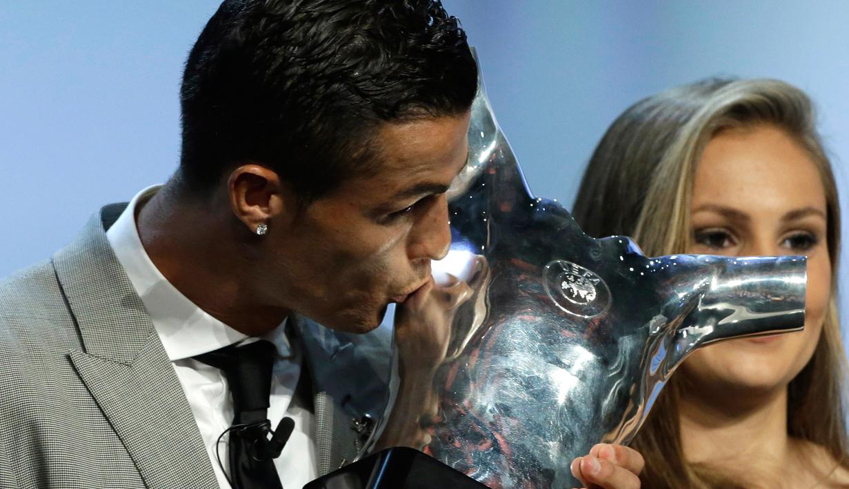 Cristiano Ronaldo mencium piala Pemain Terbaik UEFA 2016/17 di Grimaldi Forum, Monaco (24/8). Prestasi itu membuatnya menjadi pemain pertama yang meraih trofi penghargaan individu tertinggi Benua Biru sebanyak tiga kali. (AP Photo/Claude Paris)