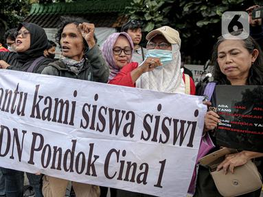 Sejumlah mahasiswa dari berbagai kampus berunjuk rasa di SDN Pondok Cina 1 Depok, Jawa Barat, Selasa (13/12/2022). Dalam aksinya, mereka menolak relokasi SDN Pondok Cina 1 yang lahannya akan digunakan untuk pembangunan masjid. (Liputan6.com/Faizal Fanani)