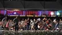 Sejumlah pengunjung berlindung saat festival musik Route 91 Harvest country setelah aksi penembakan di Las Vegas, Nevada (1/10). Pelaku penembakan disebut menembak seorang petugas keamanan dan polisi setempat. (David Becker/Getty Images/AFP)