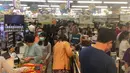 Orang-orang antre untuk membayar makanan dan belanjaan lainnya di supermarket 24 jam di Yangon, Selasa (24/3/2020). Tanggapi kasus pertama Corona COVID-19 pada Senin 23 Maret malam, warga Myanmar memadati pusat perbelanjaan untuk menyetok kebutuhan pokok dan persedian makanan. (AP/Thein Zaw)