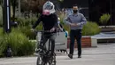 Perancang industri Kolombia Ricardo Conde mengendarai sepeda  saat memakai masker baru dengan ventilasi demi mencegah penyebaran Virus Corona COVID-19, dirancang olehnya bersama seorang dokter medis dan dua insinyur aeronautika di Bogota, Kolombia pada 30 Juli 2020. (Juan BARRETO / AFP)