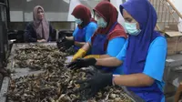 Tri Handayani sedang memantau proses pembuatan kerupuk kulit ikan patin yang dikerjakan karyawannya. Kerupuk kulitnya memiliki kisaran harga mulai dari Rp20.000 sampai Rp35.0000 per bungkusnya. (Foto: Liputan.com).