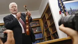 Ahli biola, Phillip Injeian menjelaskan biola Stradivarius pada konferensi pers di New York, Kamis (6/8/2015). Biola yang dibeli dengan harga Rp2,7 miliar itu kembali ke pemiliknya setelah hilang dicuri selama 35 tahun. (REUTERS/Shannon Stapleton)
