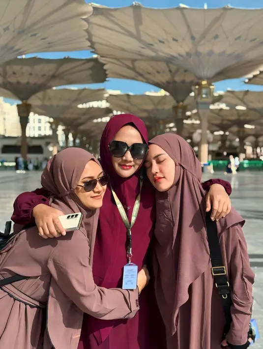 Atau potret gemas Happy Salma yang berpelukan ini. Ia mengenakan outfit serba cokelat, serasi antara abaya dan hijabnya. [Foto: Instagram/happy_asmara77]