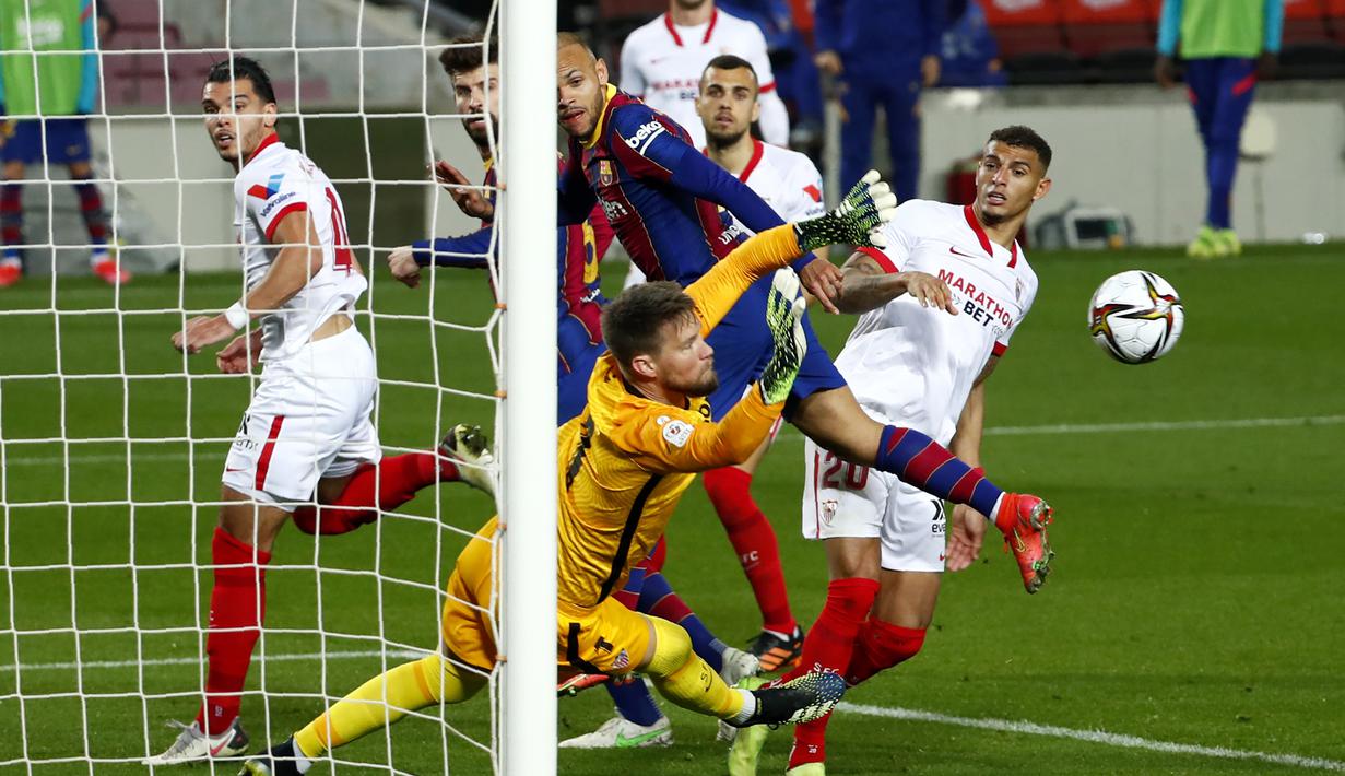 Kiper Sevilla, Tomas Vaclik berhasil menepis tendangan striker Barcelona, Martin Braithwaite (tengah) dalam laga leg kedua semifinal Copa Del Rey 2020/21 di Camp Nou Stadium, Rabu (3/3/2021). Sevilla kalah 0-3 melalui extra time dan gagal lolos ke babak final. (AP/Joan Monfort)