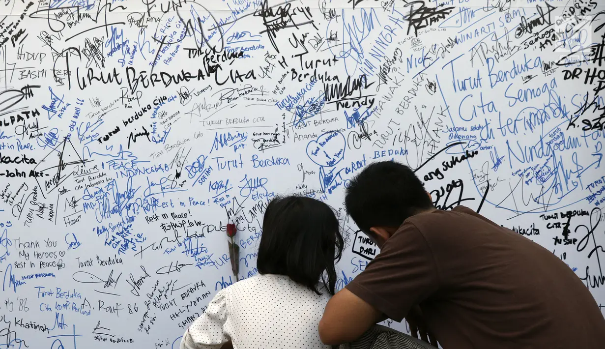 Pengunjung menuliskan dukungan buat Polri pasca kerusuhan di Rutan cabang Salemba Mako Brimob saat acara Car Free Day di Kawasan Bundaran Hotel Indonesia, Jakarta, Minggu (13/5). (Liputan6.com/Helmi Fithriansyah)