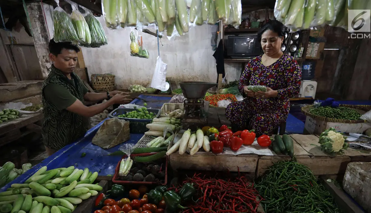 Pedagang melayani pembeli di pasar di Jakarta, Rabu (20/12).  Jelang Natal dan Tahun Baru, harga bahan pokok di Jakarta mulai merangkak naik. Namun, kenaikannya masih belum tinggi hanya berkisar Rp2.000-5.000 per kg. (Liputan6.com/Angga Yuniar)