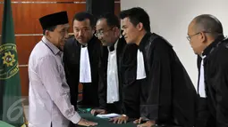 Terdakwa penerima suap kasus jual beli gas alam Bangkalan Fuad Amin berdiskusi dengan kuasa hukumnya saat sidang pembacaan vonis di Pengadilan Tipikor, Jakarta, Senin (19/10). Mantan Bupati Bangkalan itu divonis 8 tahun penjara.(Liputan6.com/Helmi Afandi)