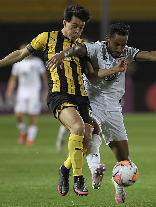 Gelandang Penarol Uruguay, Facundo Pellistri (kiri) berebut bola dengan bek Colo Colo dari Chile Ronald De La Fuente pada pertandingan fase grup Copa Libertadores di Stadion Campeon del Siglo di Banados de Carrasco, Departemen Montevideo, Uruguay, pada 29 September 2020. (AFP/Sandro Pereyra)