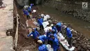 Suasana pembokaran dinding turap di saluran air kawasan Pancoran, Jakarta, Senin (28/1). Pembongkaran dilakukan untuk mengganti batu penahan turap guna mencegah kelongsoran selama musim hujan. (Liputan6.com/Immanuel Antonius)