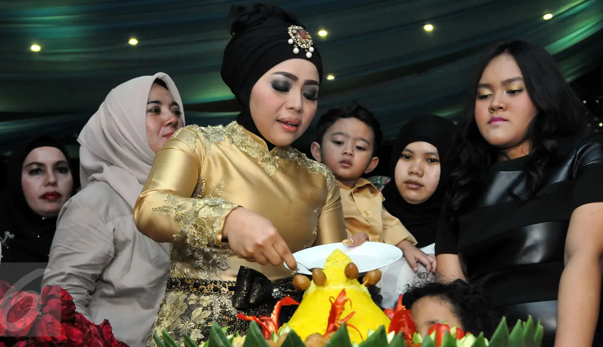 Istri Nassar, Muzdalifah memotong tumpeng pada perayaan ulang tahunnya yang ke-37 tahun di kawasan Pramuka, Jakarta Timur, Senin (15/6/2015). (Liputan6.com/Panji Diksana)