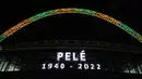 Lengkungan Stadion Wembley menyala dengan warna Brasil setelah pengumuman bahwa mantan pemain sepak bola Brasil Pele meninggal dunia, London, Inggris, 29 Desember 2022. Edson Arantes do Nascimento atau yang dikenal sebagai Pele, raja sepak bola Brasil yang menang rekor tiga Piala Dunia dan menjadi salah satu tokoh olahraga paling berwibawa abad lalu, meninggal pada usai 82 tahun di di Sao Paulo. (Kieran Cleeves/PA via AP)