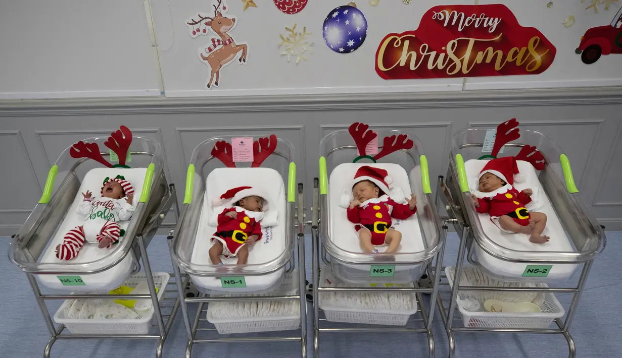 Bayi-bayi yang baru lahir mengenakan kostum sinterklas di Rumah Sakit Synphaet, Bangkok, Thailand, Selasa (24/12/2019). Bayi-bayi tersebut dipakaikan kostum sinterklas untuk menyambut Hari Raya Natal. (AP Photo/Sakchai Lalit)
