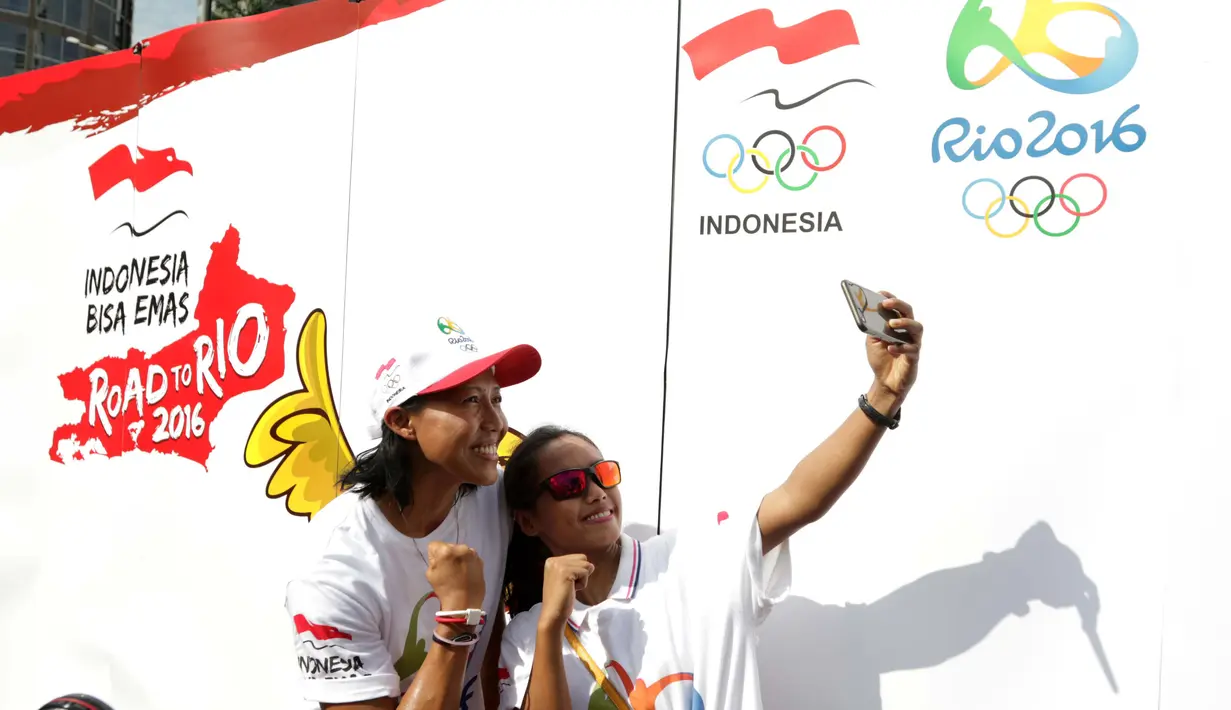 Atlet Indonesia Dedeh Erawati (kiri) dan Triyaningsih berfoto selfie saat kampanye Indonesia Bisa Emas, Road to Rio 2016 di Senayan, Jakarta, Minggu (20/3/2016). (Bola.com/Nicklas Hanoatubun)
