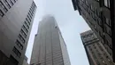 Asap mengepul saat sebuah helikopter menabrak gedung pencakar langit di pusat Manhattan, New York, Amerika Serikat, Senin (10/6/2019). Seorang pilot dilaporkan tewas dalam insiden tersebut. (AP Photo/Mark Lennihan)