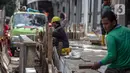 Pekerja menyelesaikan pembangunan selter di kawasan Stasiun Palmerah, Jakarta, Selasa (2/2/2021). Penataan kawasan Stasiun Palmerah mencakup pembangunan selter untuk bus, angkot, dan ojek online. (Liputan6.com/Faizal Fanani)