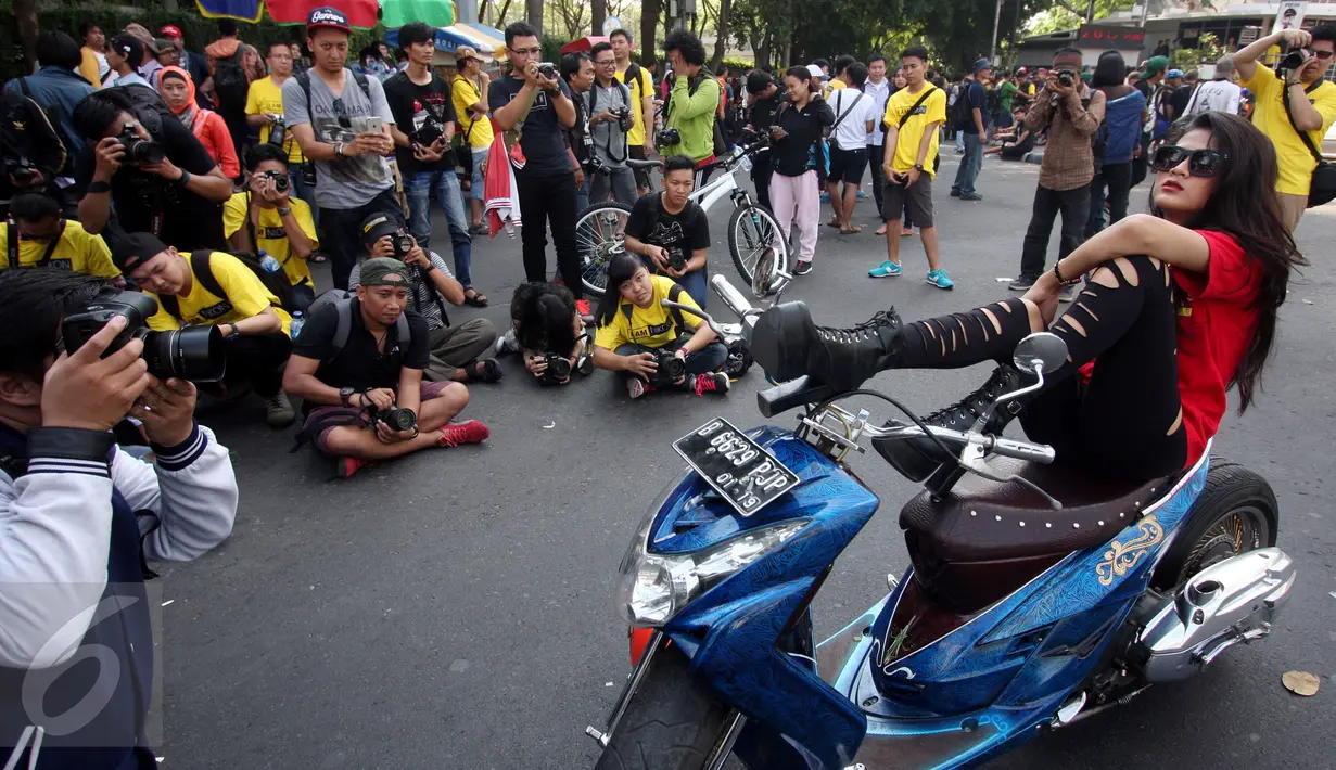 Sejumlah fotografer memotret seorang model yang berpose di atas motor di Jalan MH Thamrin, Jakarta, Minggu (19/7/2015). Momen Jakarta sepi akibat banyak yang mudik, dimanfaatkan fotografer untuk memotret model. (Liputan6.com/Johan Tallo)