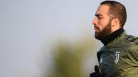 Striker Juventus, Gonzalo Higuain, tampak serius saat sesi latihan jelang laga Liga Champions di kompleks training center Juventus, Selasa (21/11/2017). Juventus akan berhadapan dengan Barcelona. (AFP/Marco Bertorello)