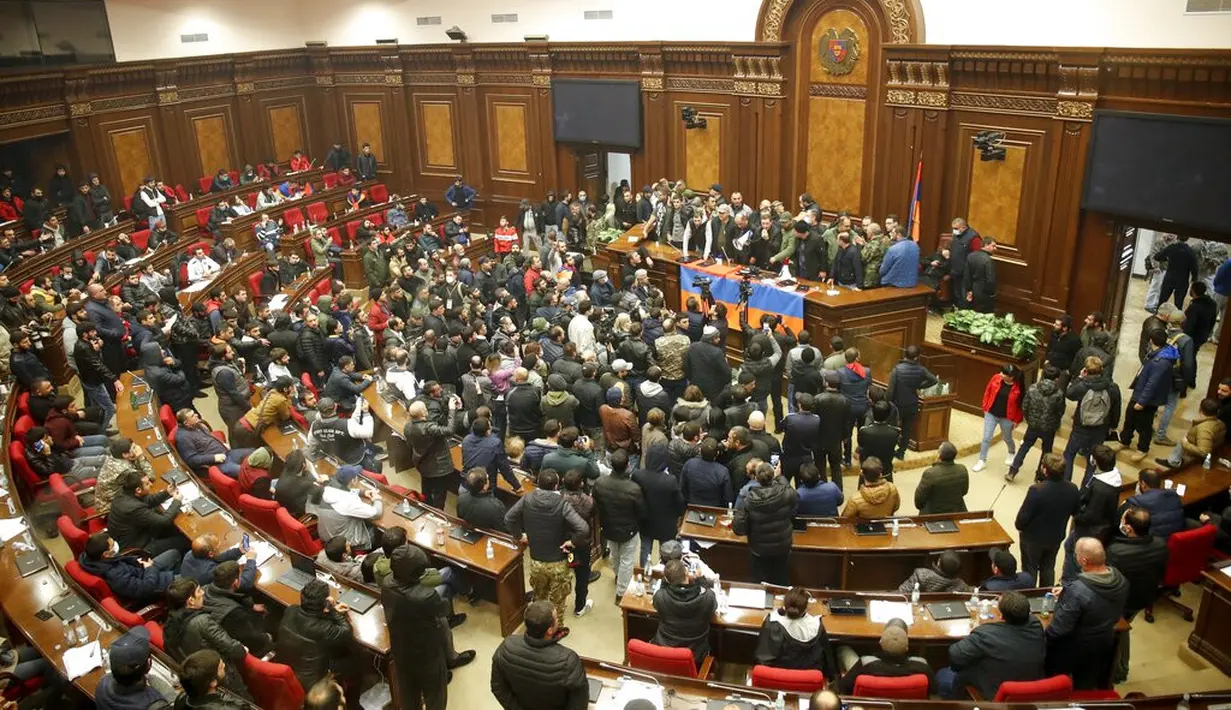 Demonstran mendengarkan pembicara saat masuk Gedung Parlemen memprotes kesepakatan untuk menghentikan pertempuran di wilayah Nagorno-Karabakh, Yerevan, Armenia, Selasa (10/11/2020). PM Armenia Nikol Pashinian menyerukan diakhirinya pertempuran dengan Azerbaijan. (AP Photo/Dmitri Lovetsky)