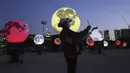 Warga berswafoto dekat instalasi bulan purnama yang bersinar di sebuah taman di Seoul, Korea Selatan, Jumat (18/9/2020). Pejabat setempat memasang bulan purnama buatan untuk meningkatkan semangat saat wabah COVID-19 sekaligus menyambut Chuseok, Thanksgiving versi Korea. (AP Photo/Ahn Young-joon)