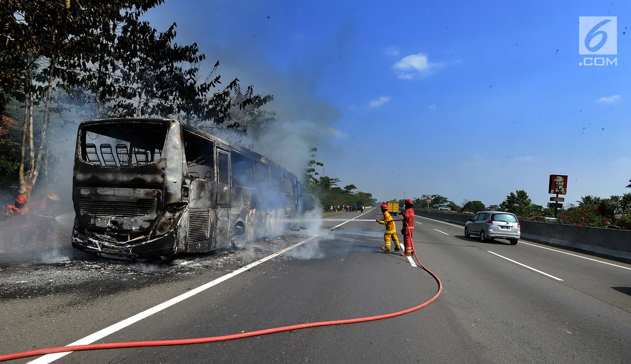 Petugas pemadam kebakaran berusaha memadamkan api yang melalap bus pariwisata nopol AB 7536 AK pada ruas tol Jagorawi arah Bogor di KM 36, Bogor, kamis (25/7/2019). Kebakaran bus ini menyebabkan kemacetan lalu lintas menuju Bogor. (merdeka.com/Arie Basuki)