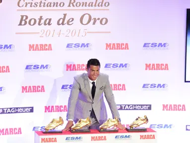 Penyerang Real Madrid, Cristiano Ronaldo berpose di depan empat sepatu emas miliknya di Madrid, Spanyol, Selasa (13/10). Ronaldo kembali menerima Golden Boot dan merupakan gelar keempat bagi dirinya setelah mencetak 48 gol. (AFP PHOTO/JAVIER Soriano)