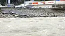Rute 41 di sepanjang Sungai Hida sebagian ambruk akibat banjir akibat hujan deras di Gero, Prefektur Gifu, Jepang tengah, Minggu (15/8/2021). Hujan deras memicu tanah longsor dan  banjir di sejumlah wilayah Jepang menyebabkan tiga orang  tewas dan memaksa evakuasi puluhan warga. (Kyodo News via AP)