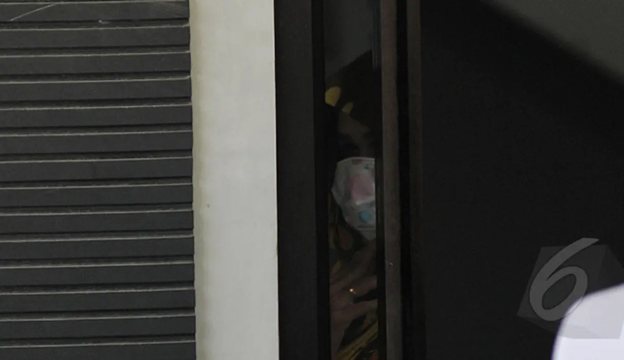 Istri Sylvester Obiekwe Nwolise‎, Fatimah melihat keadaan di luar dari celah pintu saat berada di ruang tunggu, Dermaga wijayapura Cilacap, Jawa Tengah, Jumat (6/3/2015). (Liputan6.com/Johan Tallo)