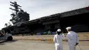 Prajurit Angkatan Laut AS terlihat menyaksikan USS Ronald Reagan kapal pembawa nuklir di pangkalan Angkatan Laut AS di Yokosuka, Tokyo, Jepang (1/10/2015). USS Ronald Reagan tiba di Jepang sehari lebih awal dari yang dijadwalkan. (REUTERS/ Yuya Shino)
