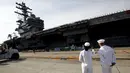 Prajurit Angkatan Laut AS terlihat menyaksikan USS Ronald Reagan kapal pembawa nuklir di pangkalan Angkatan Laut AS di Yokosuka, Tokyo, Jepang (1/10/2015). USS Ronald Reagan tiba di Jepang sehari lebih awal dari yang dijadwalkan. (REUTERS/ Yuya Shino)