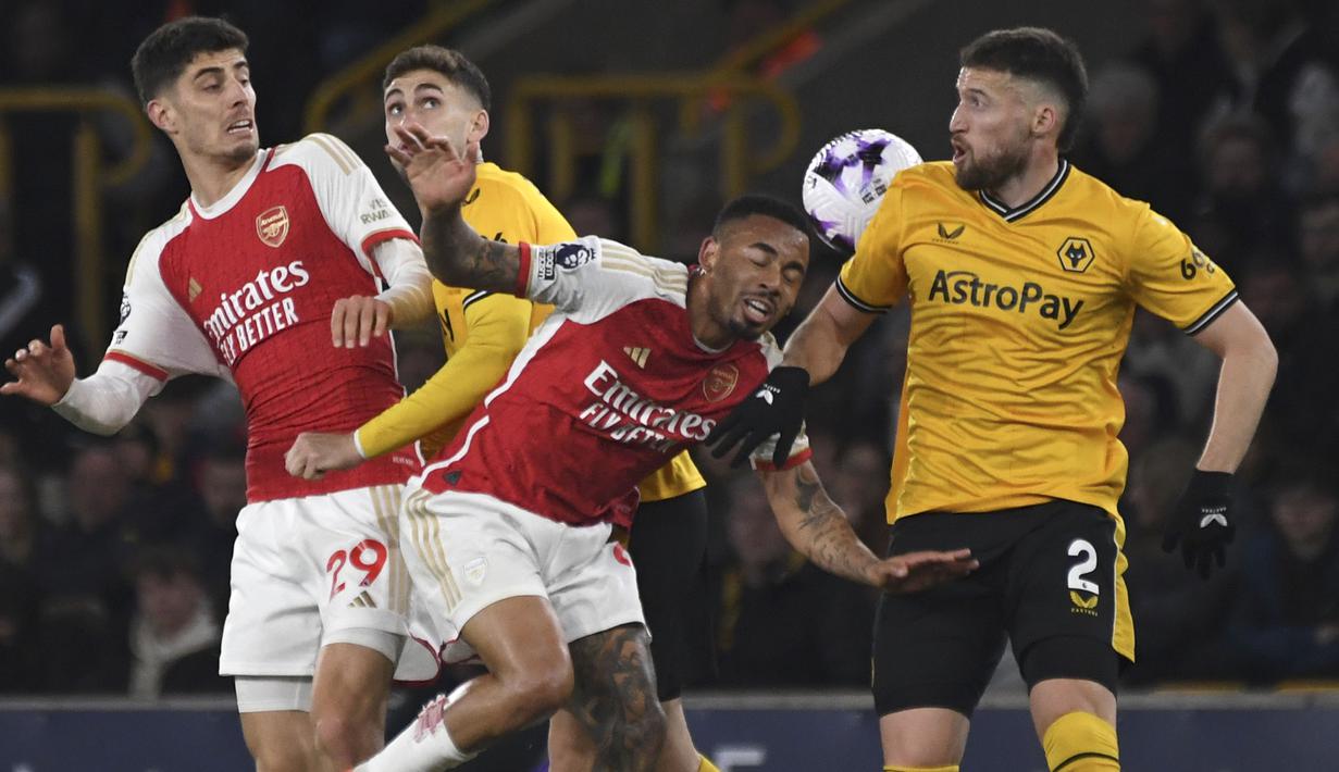 Striker Arsenal, Gabriel Jesus (tengah) menyundul bola di depan bek Wolverhampton Wanderers, Matt Doherty pada laga pekan ke-33 Premier League 2023/2024 di Molineux Stadium, Wolverhampton, Sabtu (20/4/2024). (AP Photo/Rui Vieira)