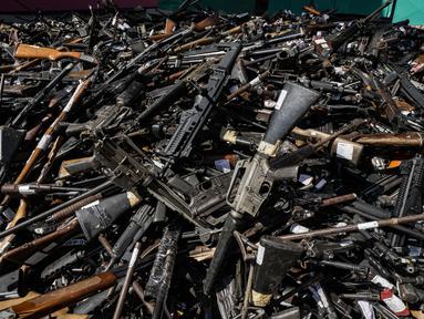Senjata yang secara sukarela diserahkan kepada polisi atau disita, ditumpuk sebelum dilebur di Santiago, Chile, Kamis (11/11/2021). Lebih dari 13.600 senjata ilegal dihancurkan, menurut komisi nasional yang mengatur senjata. (AP Photo/Esteban Felix)