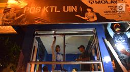 Petugas dan warga memperbaiki pos polisi yang sebelumnya dibakar massa saat peringatan Hari Buruh di Yogyakarta, Selasa (1/5) malam. Hari Buruh di Yogyakarta diwarnai aksi bakar pos polisi di pertigaan kampus UIN Sunan Kalijaga. (Liputan6.com/Gholib)