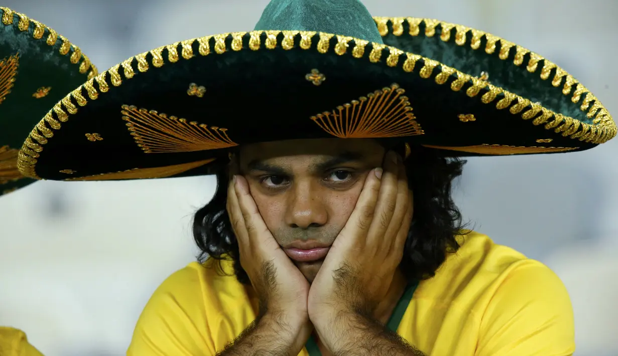 Wajah murung pendukung Brasil usai timnya dicukur Jerman 1-7 pada babak semifinal Piala Dunia 2014, Selasa (8/7/14). (REUTERS/Leonhard Foeger)