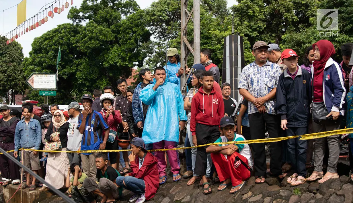 Warga melihat proses evakuasi KRL yang anjlok di kawasan Kebon Pedes, Bogor, Jawa Barat, Minggu (10/3). Kepala Daop I Jakarta Dadan Risdiansyah memastikan penanganan KRL yang anjlok selesai hari ini. (Liputan6.com/Immanuel Antonius)