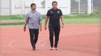 Pelatih Timnas Indonesia U-24, Indra Sjafri dan pelatih Timnas Indonesia U-17, Bima Sakti berjalan beriringan dalam waktu yang cukup lama di trek lari Stadion Madya, Gelora Bung Karno, Jakarta, Kamis (6/7/2023). (Bola.com/M Iqbal Ichsan)