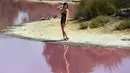 Pengunjung berpose dekat danau yang berubah warna menjadi pink di Westgate Park, Melbourne, Australia, Senin (4/3). Warna tersebut merupakan campuran dari udara hangat, cahaya matahari, sedikit hujan dan tingginya kadar garam. (William WEST/AFP)