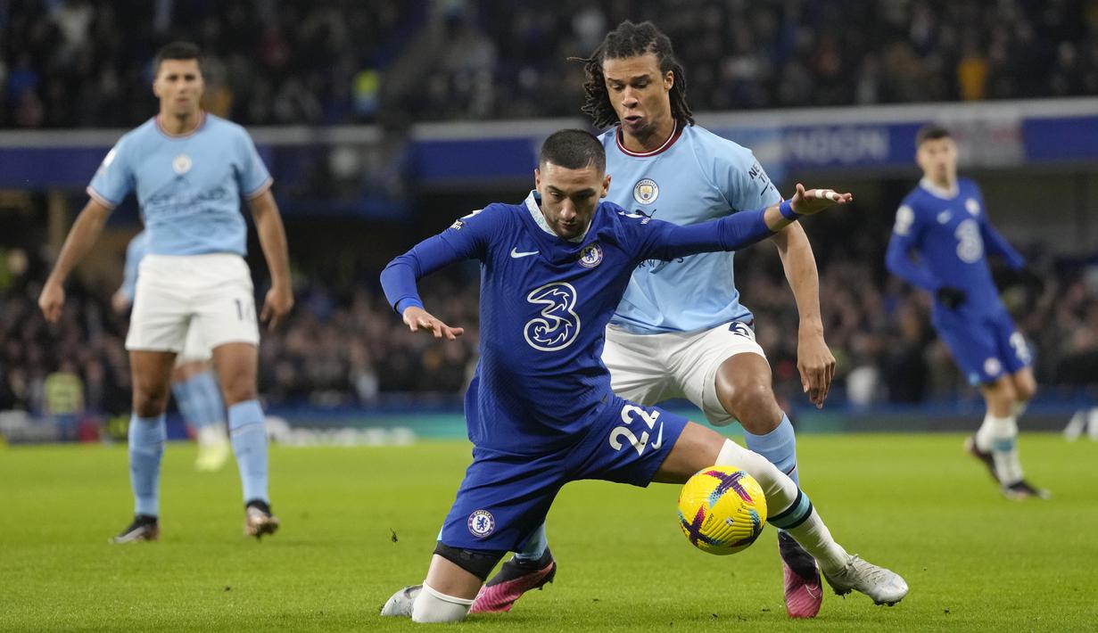 Gelandang Chelsea Hakim Ziyech dan bek Manchester City Nathan Ake  berebut bola pada matchday ke-18 Liga Inggris di Stadion Stamford Bridge, Jumat (6/1/2023) dini hari WIB. Hasil ini membuat Man City memangkas jarak dengan Arsenal di papan klasemen sementara Liga Inggris. (AP Photo/Kirsty Wigglesworth)