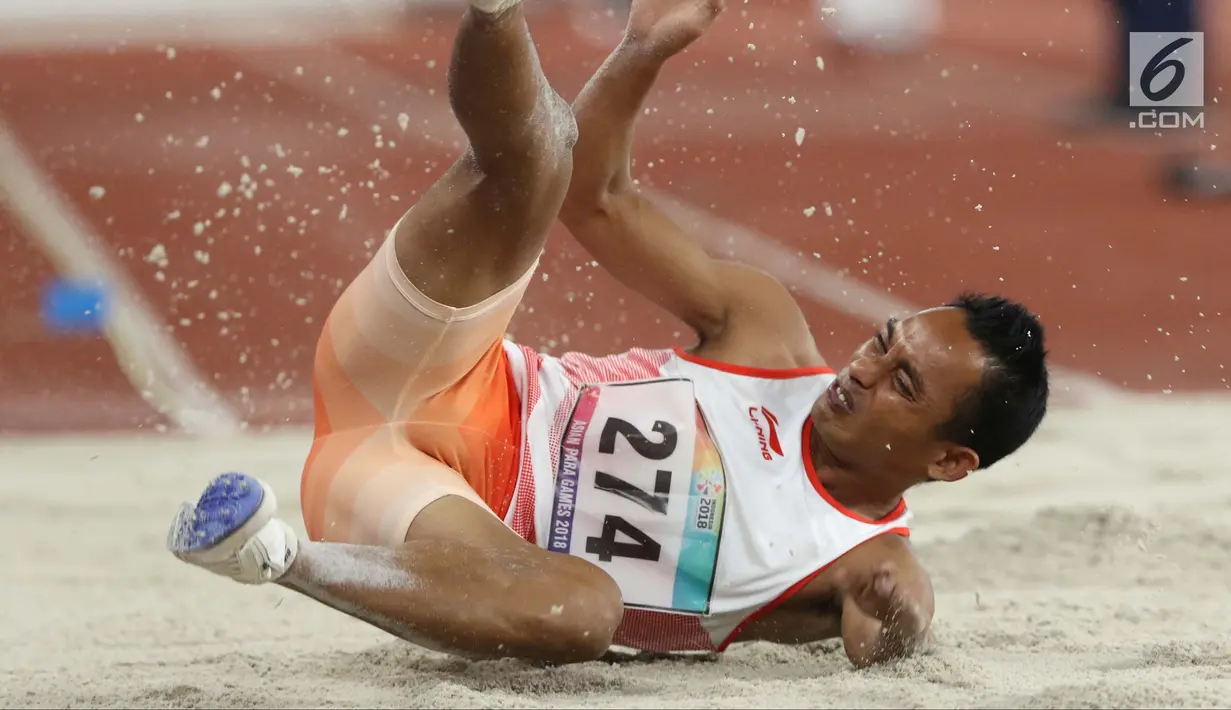 Atlet para atletik asal Indonesia, Rasyidi saat mendarat pada lomba lompat jauh T44, T62/T64 putra Asian Para Games 2018 di Stadion Utama Gelora Bung Karno, Jakarta, Jumat (12/10). (Liputan6.com/Helmi Fithriansyah)