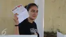 Aktris Luna Maya memperlihatkan surat suara saat mencoblos di TPS 54, Pela Mampang, Jakarta, Rabu (19/4). Luna mengaku belum mandi kepada awak media yang meliput.(Liputan6.com/Herman Zakharia)