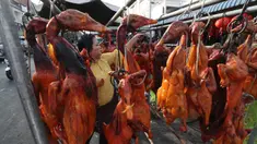 Pedagang menyiapkan babi panggang untuk perayaan Tahun Baru Imlek di Phnom Penh, Kamboja, Jumat (24/1/2020). Babi panggang menjadi menu santapan wajib bagi warga Tionghoa yang merayakan Imlek. (AP photo/Heng Sinith)
