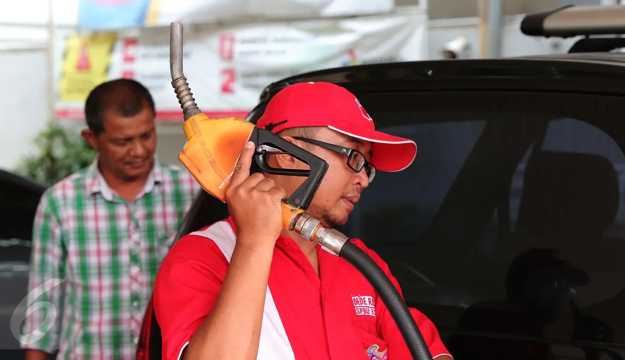 Petugas mengisi bahan bakar jenis Premium di SPBU Cikini, Jakarta, Kamis (24/12). Untuk bahan bakar jenis Premium turun Rp 150/liter dan harga solar turun sebesar Rp 800/liter. (Liputan6.com/Angga Yuniar)