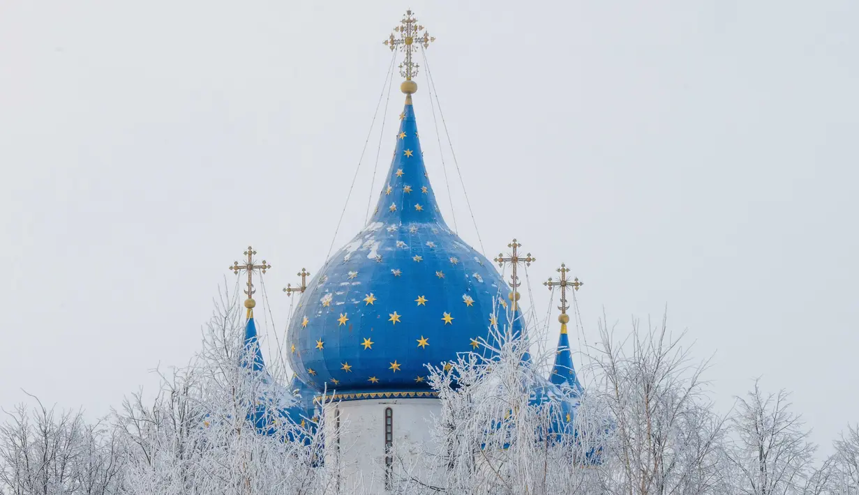 Pemandangan atap gereja yang dikelilingi pohon tertutup salju di desa wisata Suzdal, Rusia (23/1). Suzdal merupakan daerah bersejarah yang menjadi satu pemukiman tertua di Rusia. (AFP Photo/Mladen Antonov)
